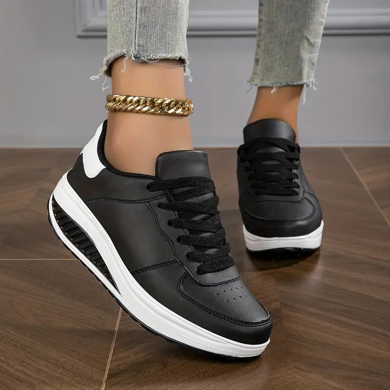 Black platform sneakers worn with a gold anklet